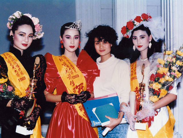 3-4动态时装的展示、流行趋势的发布，促使了模特行业的发展与竞争.1989年首届中国时装模特表演大赛在广州举行，图为：冠军（左二）叶继红，亚军（左一）柏青，季军（右一）姚佩芳与工作人员的合影（李维良）